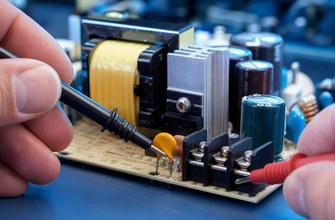 An engineer reviews a PPTC resettable fuse on a power supply circuit board and compares its Ihold and Itrip specifications.